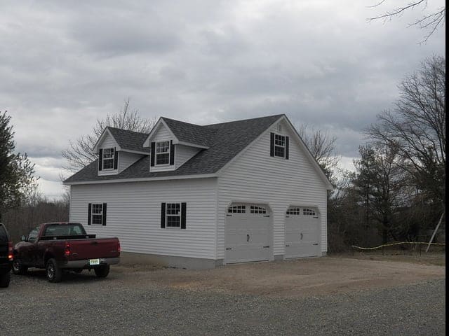 two single garage doors with windows on detached white garage