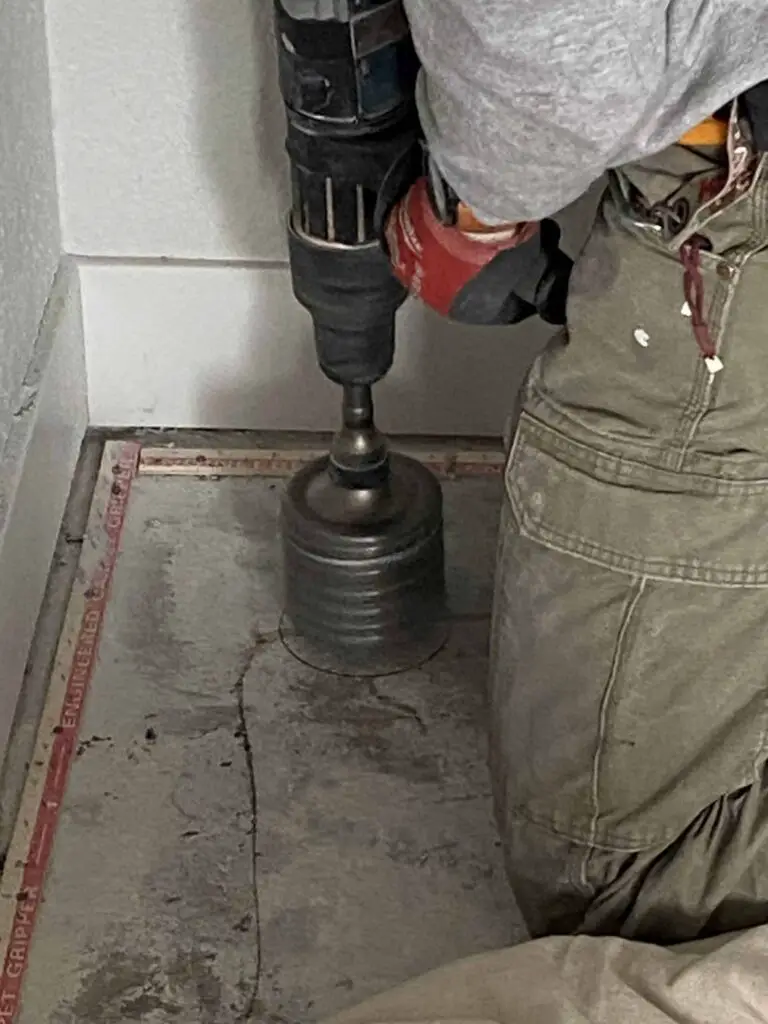 Using a hole saw to drill through the slab